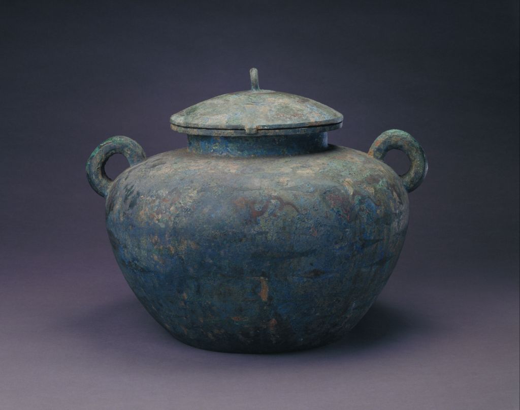 盖,器肩及腹下部饰菱纹,腹部饰龙纹.纹饰均以红铜 镶嵌. 撰稿